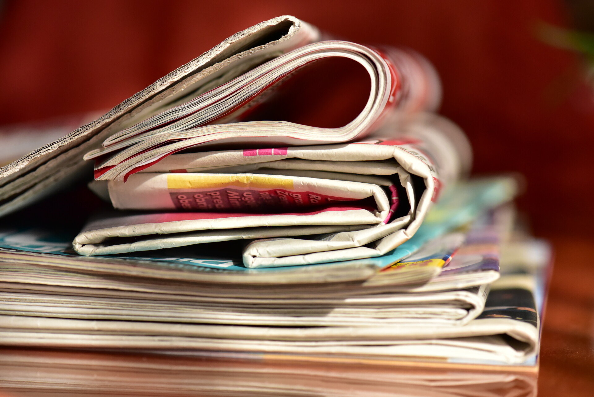 Stack of newspapers on a wooden table 2026 01 06 10 48 00 utc